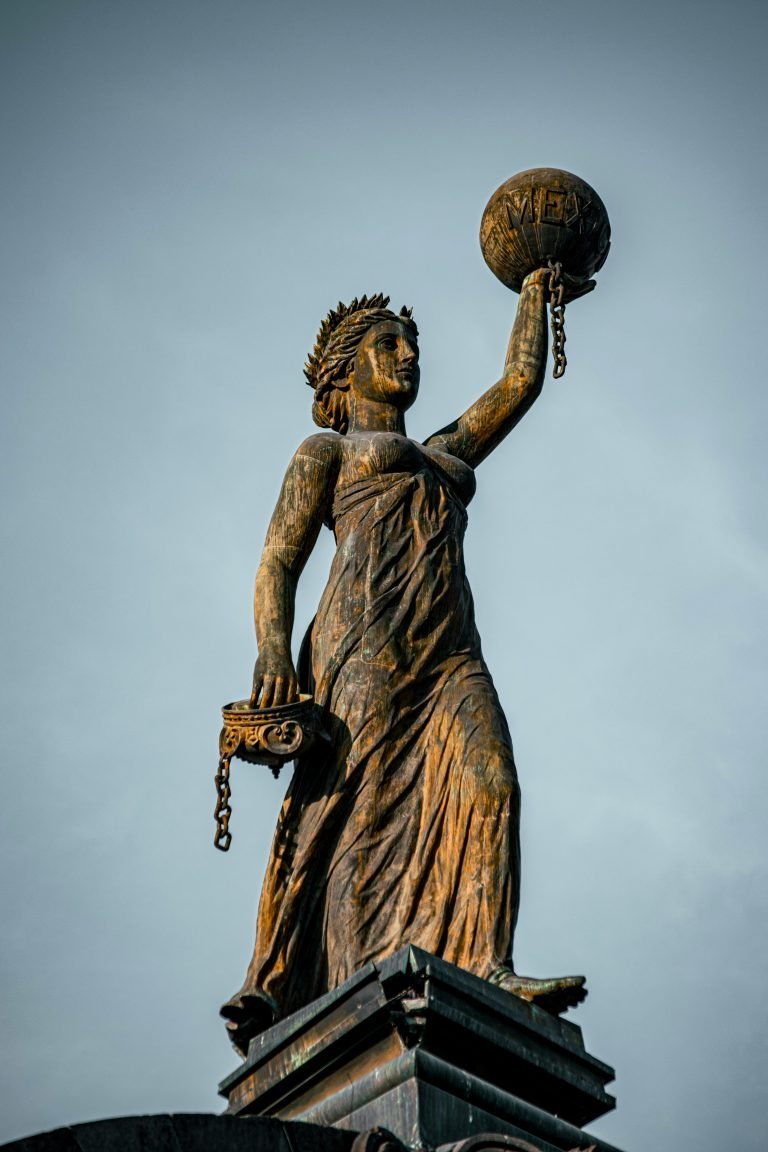 Home Bronze statue depicting justice holding scales and globe in Monterrey, Mexico.